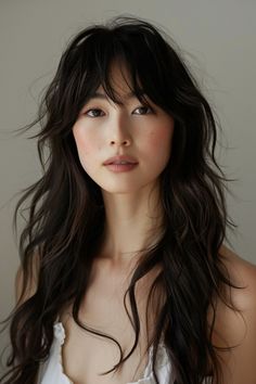 Softly layered bangs blend into long, wavy hair, creating a relaxed yet stylish look for summer 2024. This hairstyle is effortlessly beautiful, ideal for a breezy summer aesthetic. Long Wavy Hair Bangs, Wavy Asian Hair, Long Wavy Layered Hair, Layered Long Hair With Bangs, Asian Wavy Hair, Wavy Haircuts With Bangs, Blended Bangs, Long Wavy Hair With Bangs, Wavy Hair Bangs