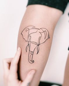 a woman's arm with an elephant tattoo on the left side of her arm