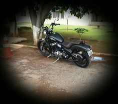 a black motorcycle parked in front of a tree