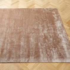 a brown area rug on top of a wooden floor