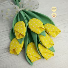 a bunch of yellow flowers sitting on top of a wooden table next to a bow