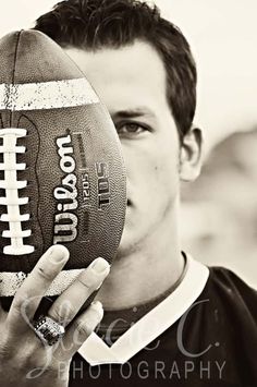 black and white photograph of a man holding a football