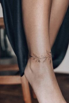 a woman's foot with a small tattoo on the top of her left leg