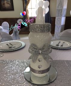 there is a cake that has been decorated with silver ribbon and bow on the top