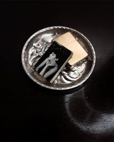 a small silver plate with a black and white photo on it