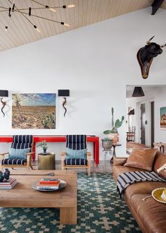 a living room with two couches, a coffee table and paintings on the wall