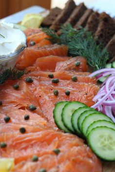 salmon, cucumber, pickles and bread on a plate