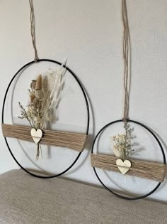 two circular metal wall hangings with flowers and hearts on the top one is made out of wood