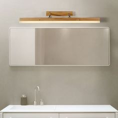 a bathroom vanity with mirror and lights above it