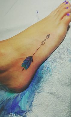 a woman's foot with an arrow tattoo on it