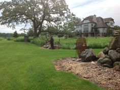 a large house sitting on top of a lush green field next to a stone wall