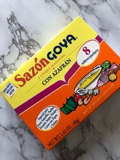 a box of sazoon goua on a marble countertop with an orange and yellow package