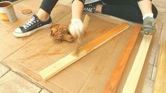 a person sitting on the ground working with wood