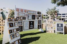 an outdoor art display with multiple pieces of artwork displayed on it's sides and in the grass