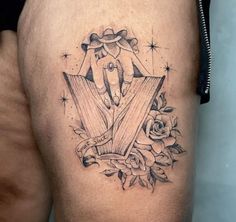 a woman's thigh with an old book and roses tattoo design on the side