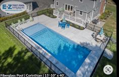 an aerial view of a swimming pool with chairs around it and a fence surrounding the pool