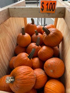 a wooden crate filled with lots of pumpkins