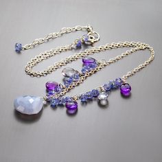 This multi gemstone necklace is created in blue and purple hues. Pretty gems in different shape in sizes are swinging from a textured sterling silver chain. These gems are briolettes of blue lace agate in the center, faceted briolettes of amethyst and blue quartz and lots of small roundels of periwinkle Tanzanite in between the larger gems. All of these gems combined with silver accents and findings look just spectacular. This beautiful necklace is delicate and fancy in the same time. It will ma Blue Lace Agate Necklace, Blue Gemstone Necklace, Multi Gemstone Necklace, Cherry Hill, Long Necklaces, Agate Necklace, Blue Quartz, Blue Lace Agate, Purple Hues