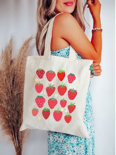 Introducing our delightful Strawberry Tote Bag! 🍓🌿 🌟 Fresh and Sweet: Carry the freshness of ripe strawberries wherever you go with this charming tote. Each strawberry is hand-painted for a unique touch. 🛍️ Practical and Stylish: This spacious tote is perfect for your daily essentials, groceries, or a day at the farmer's market. It's as practical as it is pretty. 🌎 Eco-Friendly: Made from sustainable materials, this tote bag is your stylish way of reducing single-use plastic. 🎁 Perfect Gift: Know someone who adores strawberries? This tote makes a thoughtful and eco-conscious gift. 🧡 Durable and Versatile: With reinforced handles, it's sturdy enough for all your adventures. Pink Strawberry Print Bag As Gift, Red Bag With Strawberry Print As Gift, Strawberry Print Tote Bag For Daily Use, Cute Strawberry Print Bags For Everyday Use, Summer Grocery Tote Bags, Cute Strawberry Print Tote Bag, Summer Strawberry Print Bags For Daily Use, Summer Strawberry Print Bag For Daily Use, Daily Use Strawberry Print Tote Bag