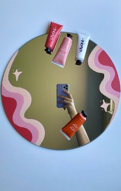 a person taking a selfie in front of a mirror with various cosmetics on it