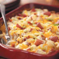 a red casserole dish filled with potatoes and ham