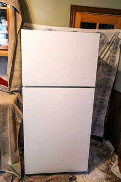 a white refrigerator freezer sitting on top of a bed