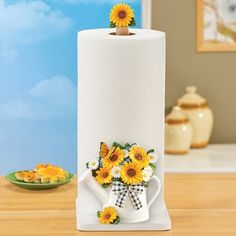 a paper towel holder with sunflowers on it and a bow tie around the top