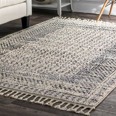 a white couch sitting next to a rug on top of a wooden floor in a living room