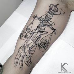 a man with a tattoo on his arm holding an hourglass and a needle in it