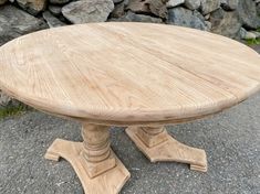 a wooden table sitting on top of a stone floor next to a pile of rocks