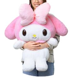 a woman holding a large pink hello kitty stuffed animal