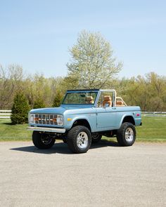 an old blue pickup truck parked in a parking lot