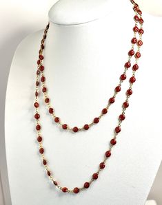 Extra Long Ruby Red Powder Glass Beaded Necklace - Gold Plated Stainless Steel - 40 Inches Elevate your style with our luxurious extra-long glittery ruby red beaded necklace. This captivating piece showcases deep ruby red glittery beads, exuding elegance and sophistication with every wear. Key Features: Length: 40 inches (101.6 cm) - ideal for layering or making a bold statement Design: Continuous strand with no clasp for a sleek, uninterrupted look Material: Premium gold-plated stainless steel, , providing a durable and opulent finish Beads: Rich ruby red beads that add a touch of timeless glamour. Versatility: Perfect for both casual and formal occasions, enhancing any outfit with a pop of rich color. Powder glass beads are made from finely ground glass. Whether you're accessorizing for Cheap Red Long Necklace, Red Beaded Necklace, Chain Jewellery, Bead Chain Necklace, Red Beaded Necklaces, Chain Necklace Gold, Jewellery Necklaces, Long Beaded Necklace, Bead Chain