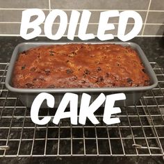 a baked cake sitting on top of a cooling rack next to a wall with the words boiled cake