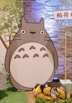 an image of a totoro in front of a sign with words written on it