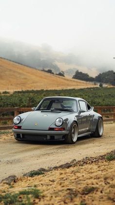 a silver car driving down a dirt road