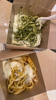 two cardboard boxes filled with different types of food and one has a fork in it