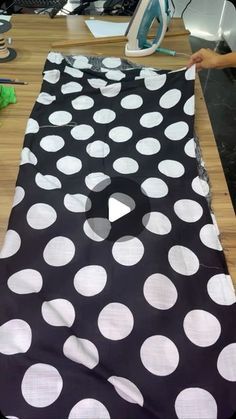 a black and white polka dot table runner on top of a wooden desk next to a computer