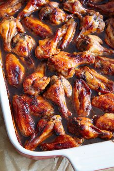 sticky coca cola chicken wings in a baking dish with text overlay that reads sticky coca cola chicken wings