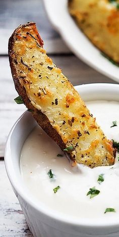 two white bowls filled with food on top of a wooden table