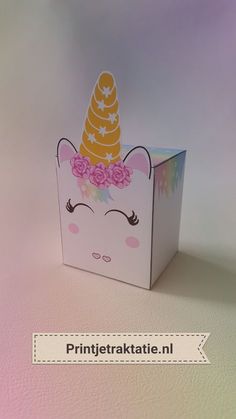 a pink box with a unicorn face and flowers on the top that says prinjetraktatie