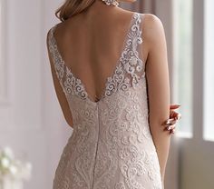 the back of a woman's wedding dress, with an intricate lace and beaded design