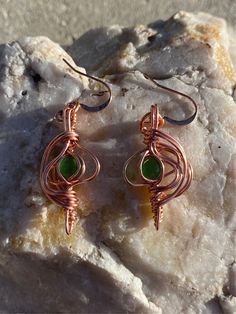 Cat eye enclosed in copper! Love the green Handmade Green Wrap Earrings As Gift, Green Wrap Earrings For Gift, Green Cabochon Metal Jewelry, Green Wire Wrapped Metal Earrings, Green Metal Cabochon Jewelry, Unique Green Metal Earrings, Green Bohemian Earrings With Copper Wire, Bohemian Green Earrings With Copper Wire, Green Bohemian Copper Wire Earrings