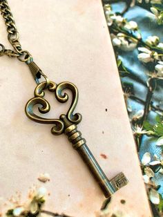 "Charming vintage French Victorian brass key charm necklace. This necklace was hand-crafted by me and features a beautiful, ornate Victorian brass key that came from France. The key is attached to a vintage brass curb chain watch chain & two strands of dark brown leather. The necklace measures 34\" long. The key drops down from a dog clip clasp by 3-3/4\". It fastens with a brass hook clasp. An everyday necklace sure to become a favorite!" Vintage Gold Jewelry With Keys, Gold Brass Necklace With Keys, Antique Gold Necklaces With Two Keys, Vintage Key Necklaces As Gift, Vintage Gold Necklaces With Keys, Bronze Brass Necklace With Keys, Vintage Metal Jewelry With Two Keys, Classic Key Necklace, Vintage Metal Jewelry With Keys