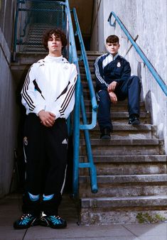 two young men are sitting on the stairs