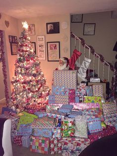 a christmas tree is surrounded by wrapped presents