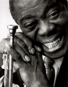 a black and white photo of a smiling man holding a cane in his right hand