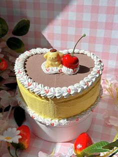 a heart shaped cake sitting on top of a table next to some flowers and cherries