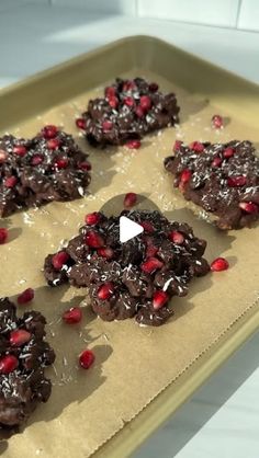 cookies with chocolate and pomegranates are on a baking sheet, ready to be baked