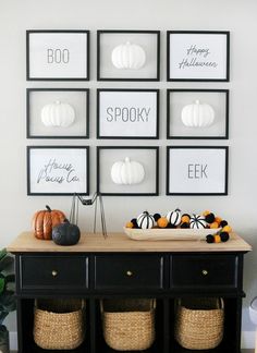 black and white halloween decor with pumpkins on the sideboard in front of it